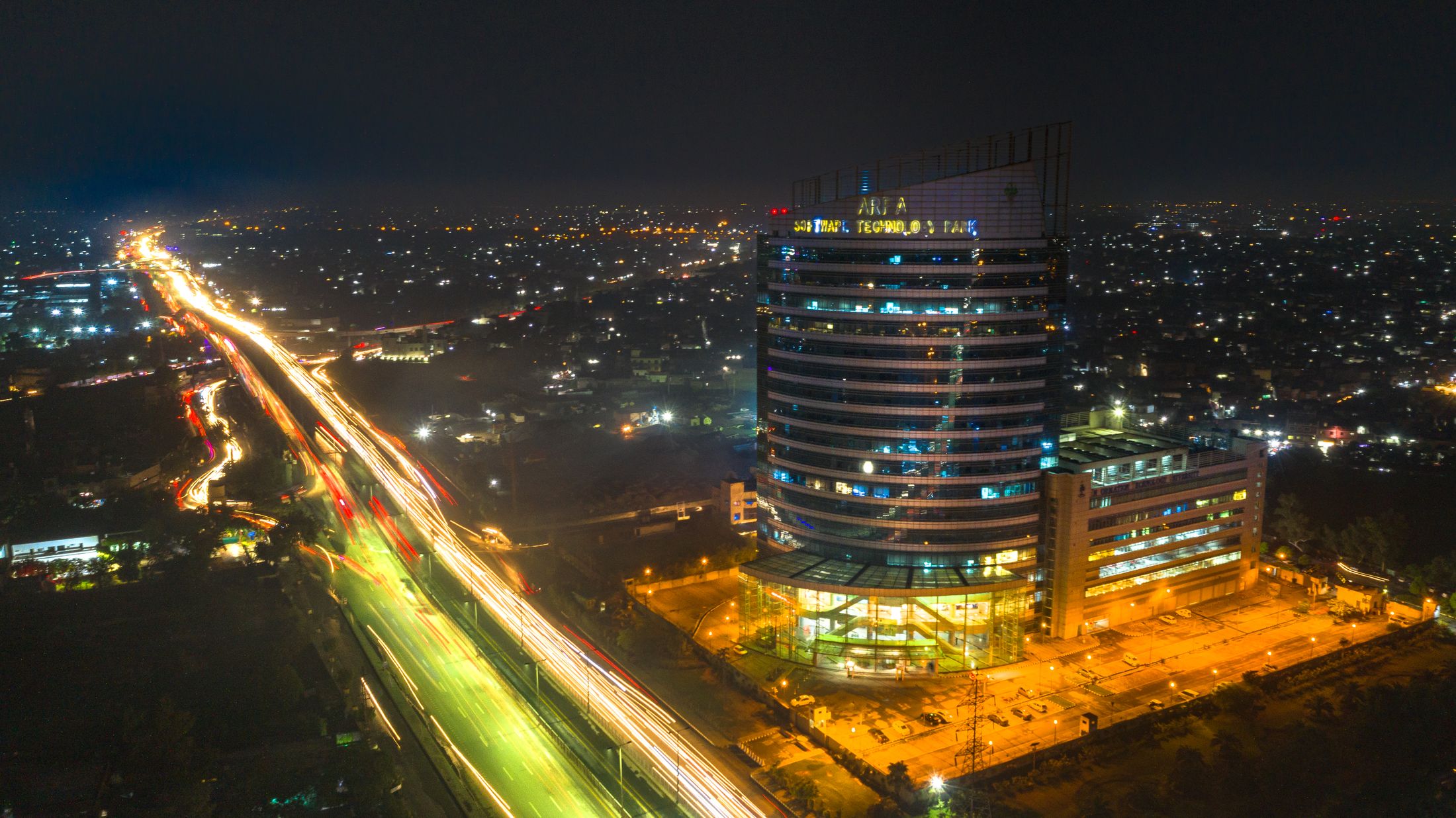 Nighttime traffic trails beside Arfa Software Technology Park in Lahore